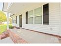 Inviting front porch with brick accents, white pillars, and a modern front door at 1028 Gibson St, Albemarle, NC 28001