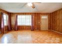 Sunlit living room with wood paneled walls and beautiful parquet flooring at 105 Hopewell Church Rd, Shelby, NC 28152