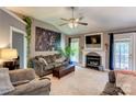 Cozy living room features a fireplace and a ceiling fan for comfort at 1209 Danielle Downs Se Ct, Concord, NC 28025