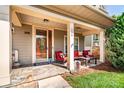 Inviting front porch with stone flooring, comfortable seating, and a decorative door wreath for curb appeal at 128 Aztec Cir, Mooresville, NC 28117