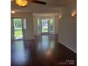 Open living area with hardwood flooring, a door to a patio, and natural light from multiple windows at 13039 Peacock Ln, Charlotte, NC 28215