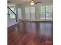 Bright living room featuring hardwood floors, a ceiling fan, and large windows at 13039 Peacock Ln, Charlotte, NC 28215