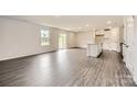 Open-concept living room with wood floors, natural light from sliding glass doors, and an island kitchen at 146 Astor St, Troutman, NC 28166