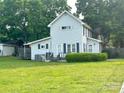 Spacious backyard featuring a well-maintained lawn, a small deck, and mature trees providing shade at 156 Spruce St, Badin, NC 28009