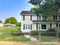 Inviting two-story home with black shutters and a well-manicured lawn partially enclosed by a chain link fence at 156 Spruce St, Badin, NC 28009