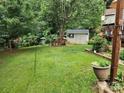 Spacious backyard featuring a shed, bench, mature trees, and lush lawn for outdoor enjoyment at 167 Foxtail Dr, Mooresville, NC 28117