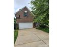 Brick home with a two-car garage, featuring a well-maintained lawn and mature trees at 167 Foxtail Dr, Mooresville, NC 28117