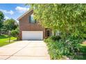Beautiful brick home boasts an attached garage, long driveway, and lush front yard landscaping at 167 Foxtail Dr, Mooresville, NC 28117