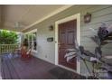 Cozy front porch featuring a dark wood floor, white trim, and red rocking chairs for relaxing at 1701 Truman Rd, Charlotte, NC 28205