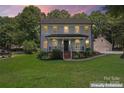 Charming two-story home features a welcoming front porch, complemented by a well-manicured lawn and lush landscaping at 18733 Bluff Point Rd, Cornelius, NC 28031