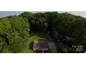 Aerial view of a cozy home nestled among lush green trees on a sunny day at 214 Cottage Pl, York, SC 29745