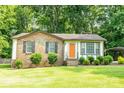 Charming brick home with a tidy lawn, featuring an orange front door and a covered parking area at 214 Cottage Pl, York, SC 29745