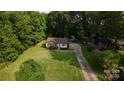 Charming single-story home with a brick facade, long driveway, and large lawn at 214 Cottage Pl, York, SC 29745