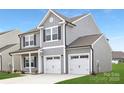 Newly constructed home boasting a two-car garage, gray siding, and a well-maintained front yard at 219 Redondo Dr # 65, Wingate, NC 28174