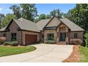 Charming brick home boasts an attached garage and a well-maintained front yard with mature trees at 2341 Shiny Leaf Dr, Denver, NC 28037