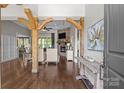 Open-concept living room featuring hardwood floors, stone fireplace, and wood beams at 2341 Shiny Leaf Dr, Denver, NC 28037