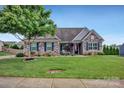 Charming home with stone accents, neat landscaping, and a well-manicured lawn at 246 Bushney Loop, Mooresville, NC 28115