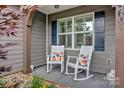 Inviting front porch with rocking chairs, decorative pillows, and views of the landscaped yard at 246 Bushney Loop, Mooresville, NC 28115