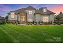 Elegant two-story home boasting a brick and stone facade, manicured lawn, and lush landscaping for enhanced curb appeal at 300 Wheatberry Hill Dr, Weddington, NC 28104