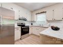 Bright kitchen with white cabinets, stainless steel appliances, stylish subway tile backsplash, and marble countertops at 3043 Charles Rd, Shelby, NC 28152