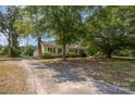 Cozy home on a tree-filled lot featuring a long driveway and lush surrounding greenery at 3595 Mt Holly Rd, Edgemoor, SC 29712