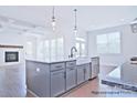 Open kitchen with a large island, farm sink, and stainless steel appliances at 4178 Millstream Rd, Denver, NC 28037