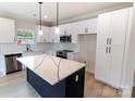 Bright kitchen boasts white cabinets, stainless appliances, and navy center island at 619 Billingsley Rd, Charlotte, NC 28211