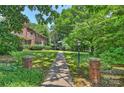 Lovely walkway leading to brick home, with lush greenery and lamp post at 6434 Sardis Rd, Charlotte, NC 28270