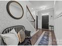 Inviting entryway featuring a decorative mirror, staircase, stylish bench, and a patterned rug leading to the front door at 6438 Hove Rd, Mint Hill, NC 28227