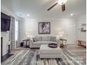 Cozy living room featuring a modern sofa, fireplace, ceiling fan, and neutral decor at 647 R L Stowe Rd, Belmont, NC 28012