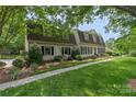 Traditional home with a manicured lawn, mature trees, and a welcoming walkway at 7213 Lancer Dr, Charlotte, NC 28226