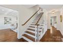 Elegant stairway with dark wood treads and white risers, leading to an open living area at 7213 Lancer Dr, Charlotte, NC 28226