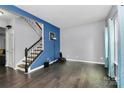 Bright and airy living room boasts hardwood floors, staircase, and natural light, ready for your personal touch at 7434 Dover Mill Sw Ln, Concord, NC 28025