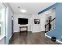 Spacious living room features hardwood floors, a blue accent wall, and offers easy access to the home's entrance at 7434 Dover Mill Sw Ln, Concord, NC 28025