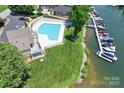 Aerial view of a community pool, marina, and waterfront with lush greenery and boat slips at 7881 Mariners Pointe Cir, Denver, NC 28037
