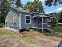 A cozy home with blue siding and white trim, featuring a covered porch and visible wear at 839 S Chester St, Gastonia, NC 28052