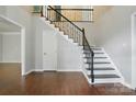 Bright foyer features hardwood floors, a staircase with iron spindles, and neutral paint at 8708 Piccone Brook Ln, Charlotte, NC 28216