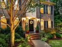 Inviting front porch featuring a wreath, sconces, and well-manicured landscaping at 105 Beech Bluff Dr, Mount Holly, NC 28120