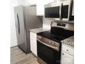 Updated kitchen featuring stainless steel appliances, granite countertops, and white cabinetry at 11010 Harrowfield Rd, Charlotte, NC 28226