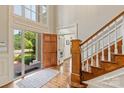 Inviting foyer with hardwood floors, staircase, and a view of the landscaped front yard through the open door at 11723 Oakland Hills Pl, Charlotte, NC 28277