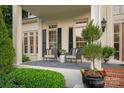 Charming front porch featuring outdoor seating, decorative plants, and classic architectural details at 11723 Oakland Hills Pl, Charlotte, NC 28277