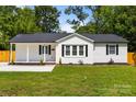 Cozy home featuring freshly painted white exteriors, dark shutters, and a well-maintained green lawn at 1319 Mt Gallant Rd, Rock Hill, SC 29732