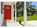 Inviting front porch with white columns and a red door, overlooking a lush green lawn at 1319 Mt Gallant Rd, Rock Hill, SC 29732