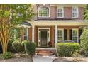 Charming front porch with brick accents, trimmed bushes, and a well-manicured garden bed at 1336 Dobson Dr, Waxhaw, NC 28173