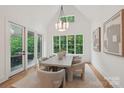 Airy dining room with large windows, stylish lighting, and access to the outdoor patio at 213 Crest Ct, Weddington, NC 28104