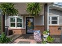 Inviting front porch with lush ferns, flower decor, and brick accents creating a warm welcome to the home at 2206 Whitworth Rd, Cherryville, NC 28021