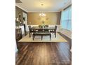 Formal dining room with modern chandelier, dark wood floors, and elegant furniture arrangement at 2634 Treeline Dr, Concord, NC 28027