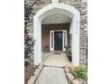 Charming front entrance with black door, stone accents, and potted plants welcoming you home at 2634 Treeline Dr, Concord, NC 28027