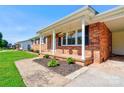Inviting front porch with hanging plants and a brick facade at 3413 Fallston Rd, Shelby, NC 28150