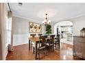 Elegant dining room featuring wood floors, chandelier, and view into the bright, airy kitchen at 4612 Maple Crest Pl, Harrisburg, NC 28075